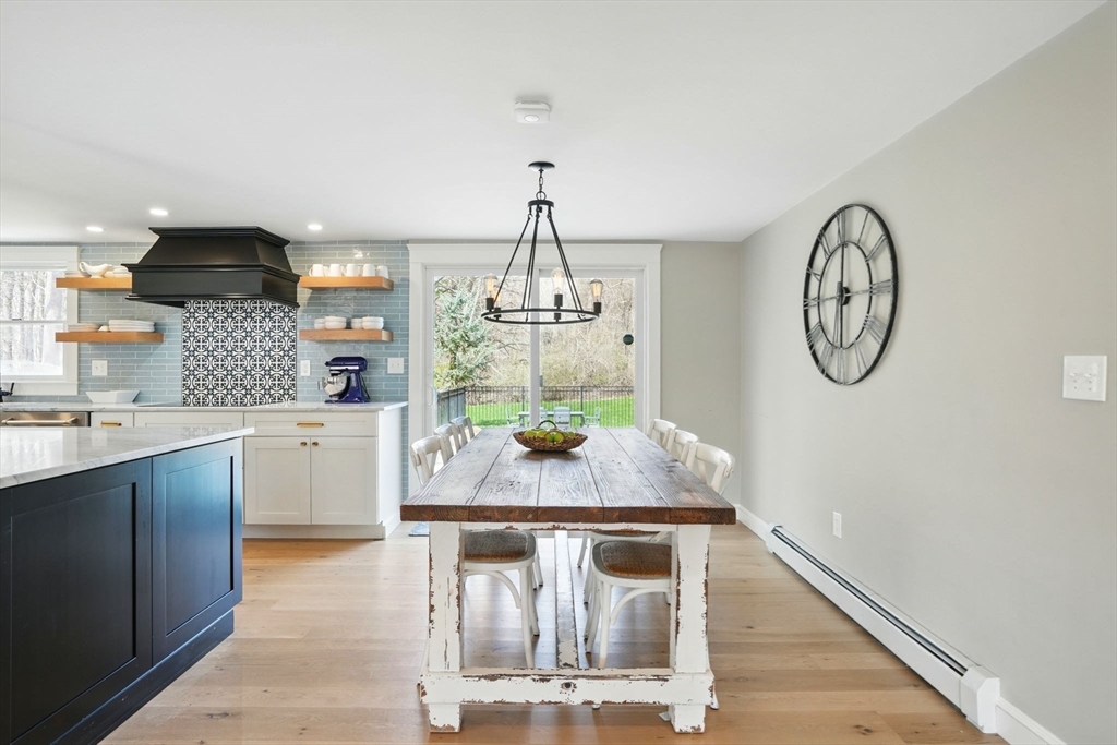 11 Old Oaken Bucket Road Norwell, MA 02061 - Photo 13 of 39 a dining room with kitchen island stainless steel appliances granite countertop a sink a stove top oven a chimney and a window