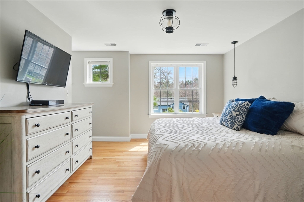 11 Old Oaken Bucket Road Norwell, MA 02061 - Photo 21 of 39 a bedroom with a large bed and a flat tv screen on dresser