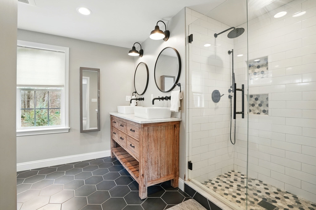 11 Old Oaken Bucket Road Norwell, MA 02061 - Photo 24 of 39 a bathroom with a double vanity sink a mirror a glass door a shower and a window