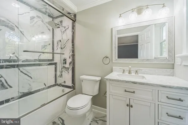 a bathroom with a granite countertop toilet sink and mirror