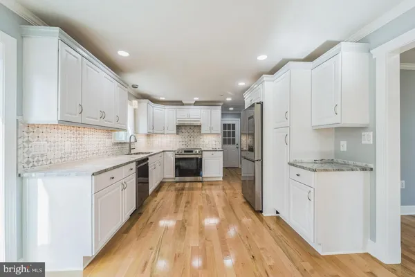 a kitchen with granite countertop white cabinets and white appliances