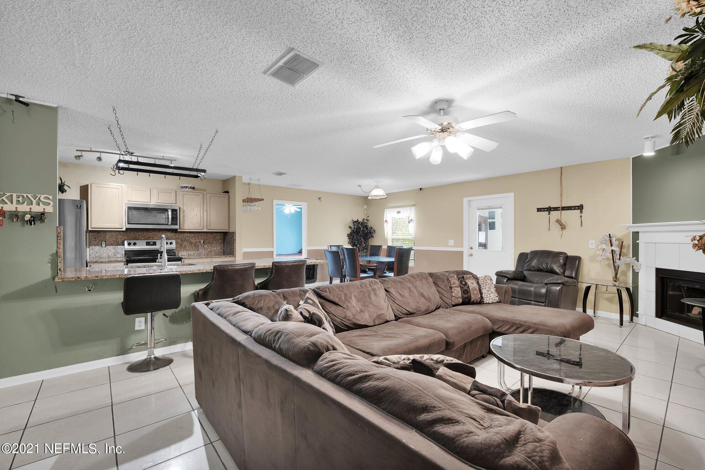 2603 Springwillow Drive Jacksonville, FL 32221 - Photo 15 of 30 a living room with furniture kitchen view and a fireplace