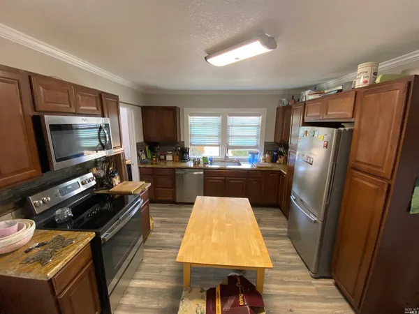 a kitchen with a refrigerator a sink and a stove top oven