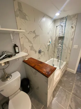 a bathroom with a granite countertop sink toilet and shower