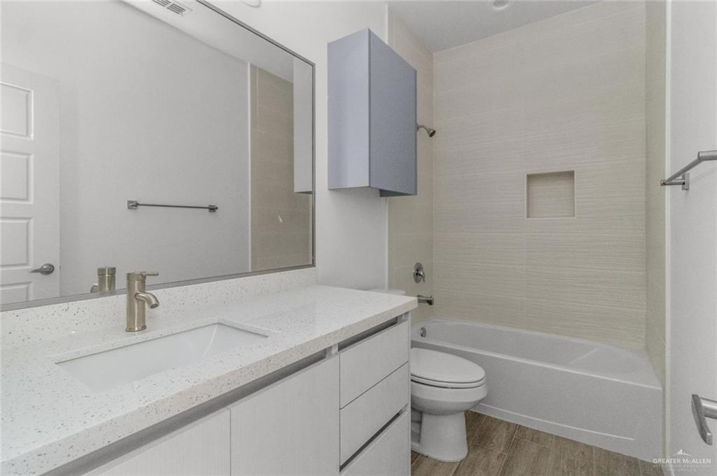 304 West Campeche Avenue, Unit 1 Alton, TX 78573 - Photo 10 of 11 Full bath with vanity, light wood-type flooring, and shower / washtub combination