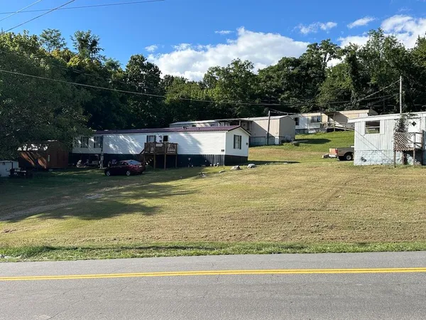 a view of a swimming pool with lawn chairs and a big yard