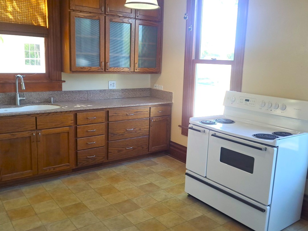 Rich wood cabinetry paired with durable countertops highlights this functional culinary space.