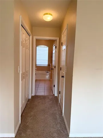 a view of a hallway with wooden shelves