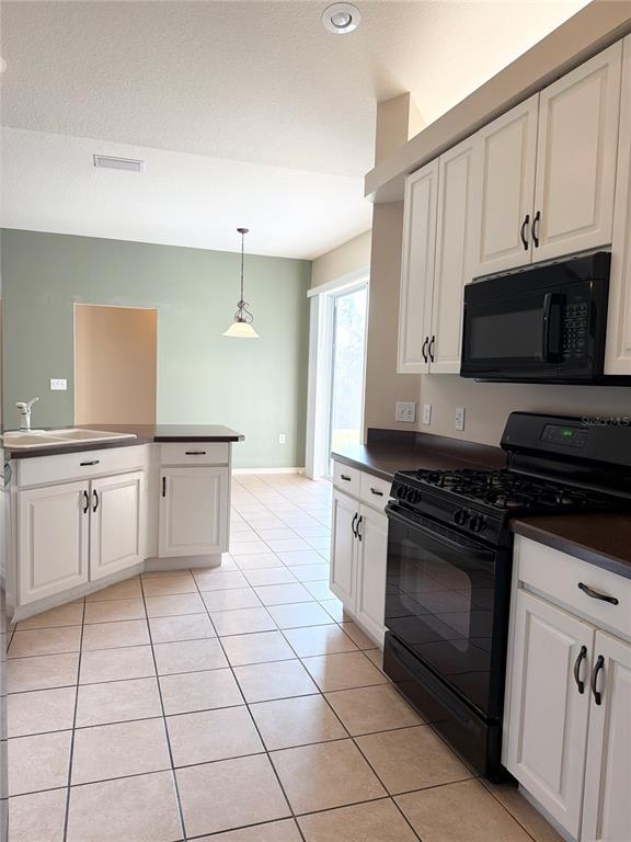 31224 Crestmont Court Wesley Chapel, FL 33543 - Photo 17 of 36 a kitchen with stainless steel appliances granite countertop a stove a sink and a microwave