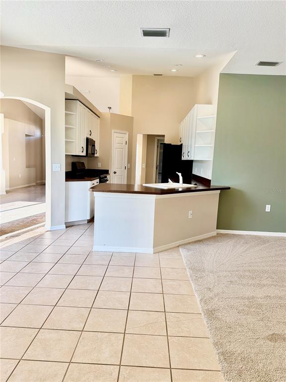 31224 Crestmont Court Wesley Chapel, FL 33543 - Photo 20 of 36 a kitchen with stainless steel appliances a sink a stove top oven a counter space and cabinets
