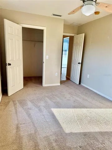 an empty room with closet and mirror