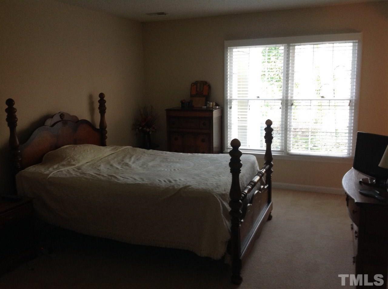 2632 Cottage Circle Raleigh, NC 27613 - Photo 8 of 10 a bed sitting in a bedroom next to a window