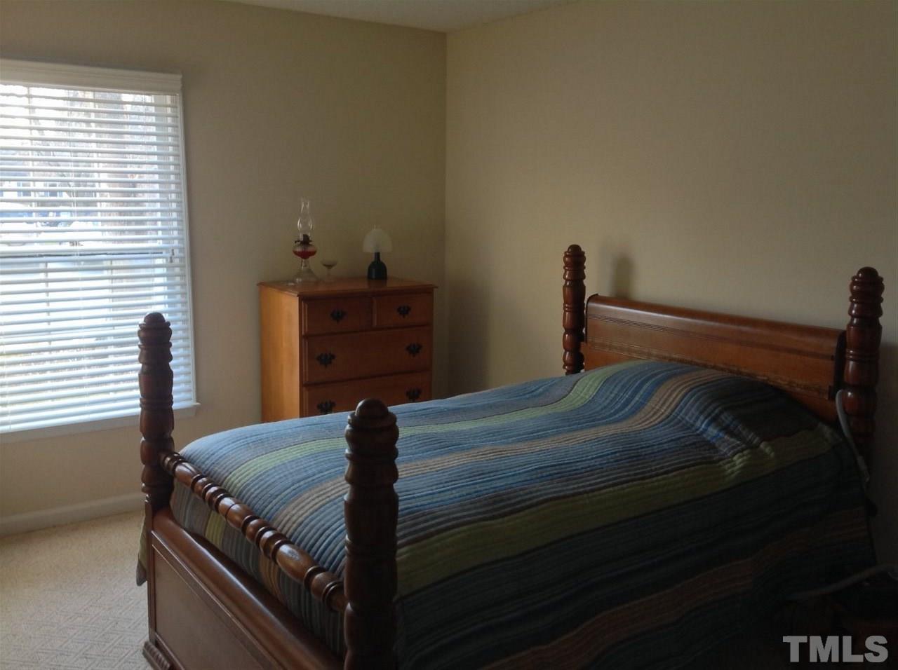 2632 Cottage Circle Raleigh, NC 27613 - Photo 9 of 10 a bed sitting in a bedroom next to a window