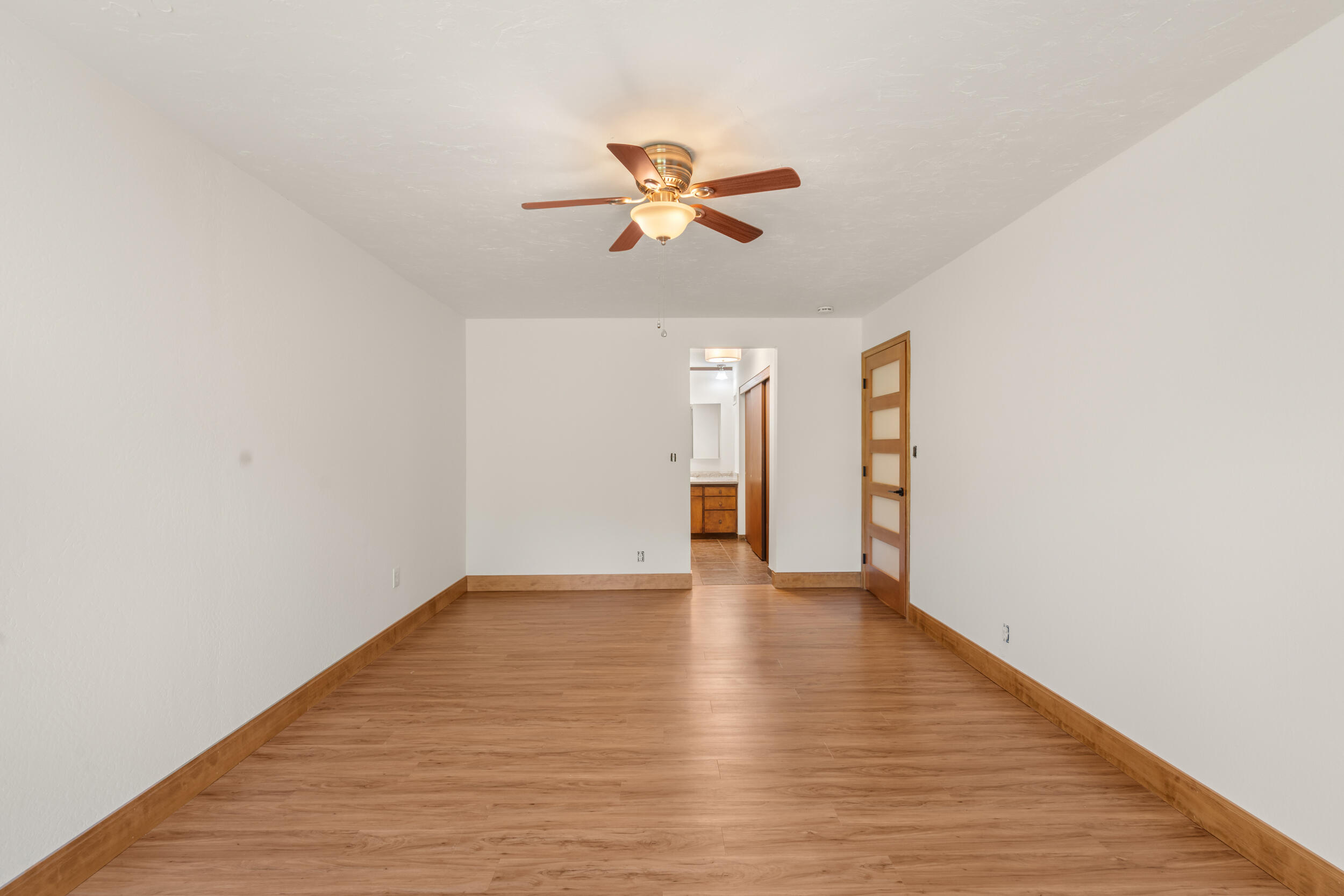 3583 Ross Lane Central Point, OR 97502 - Photo 24 of 52 a view of an empty room with wooden floor and a ceiling fan