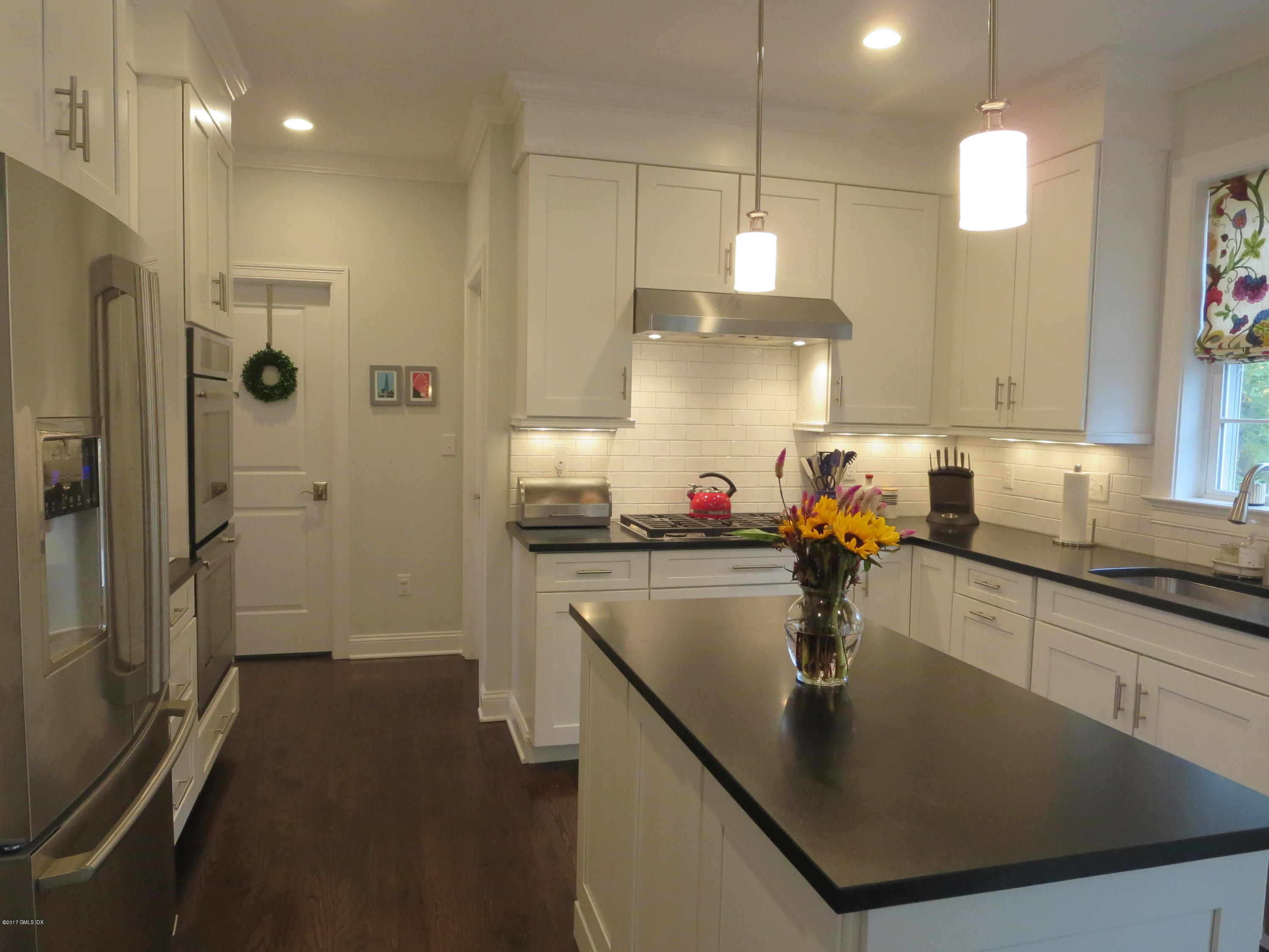551 River Road Cos Cob, CT 06870 - Photo 11 of 40 a kitchen with kitchen island a counter top space a sink a refrigerator and cabinets
