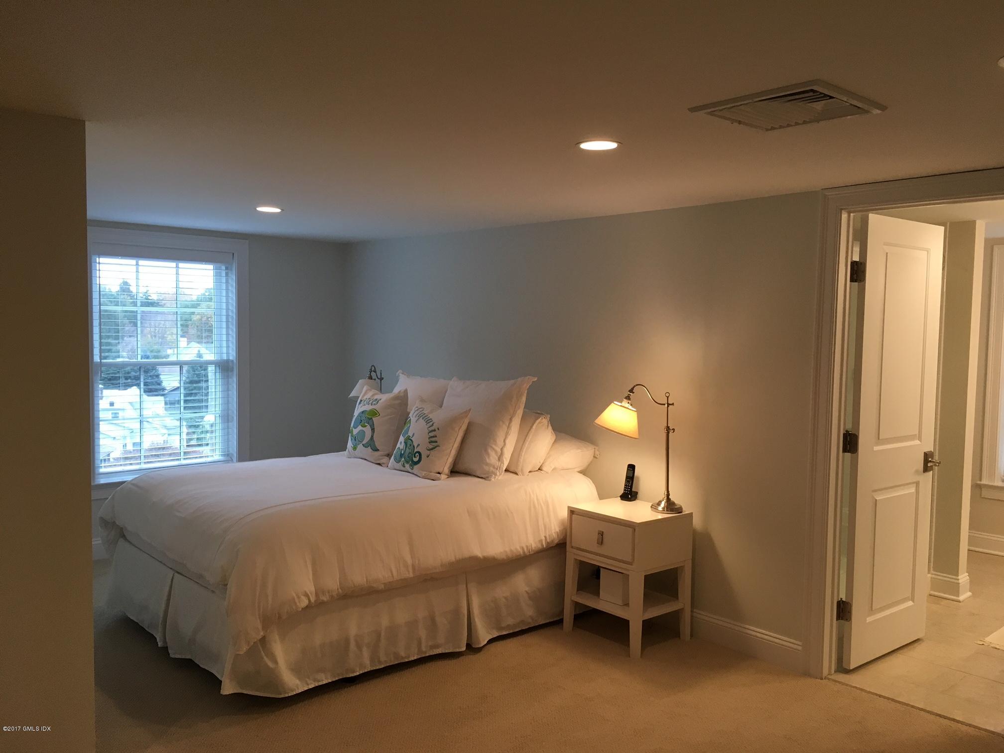 551 River Road Cos Cob, CT 06870 - Photo 25 of 40 a bedroom with a bed and a lamp