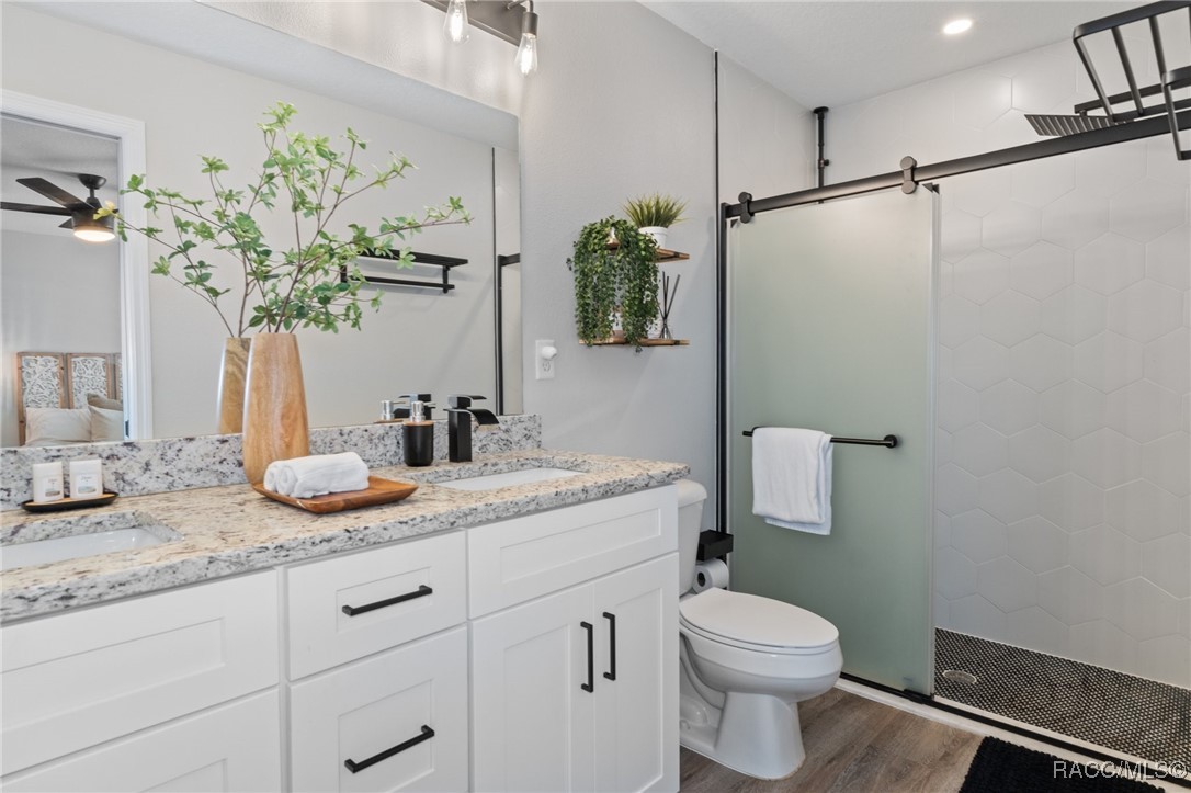 4865 South Tromp Loop Homosassa, FL 34448 - Photo 13 of 30 a bathroom with a granite countertop sink a toilet and a mirror