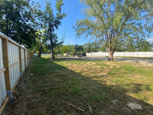 a view of yard with tree and wooden fence
