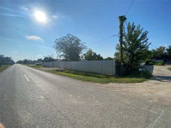 a view of wooden fence and trees in the background