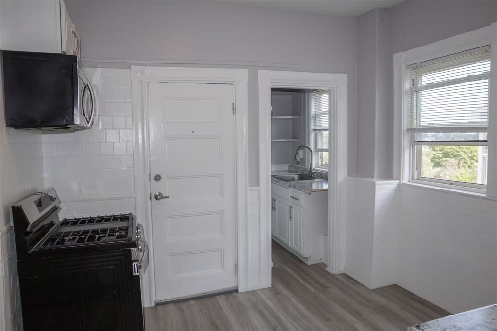 285 Medford Street, Unit 2 Somerville, MA 02143 - Photo 3 of 11 a view of a kitchen from the hallway