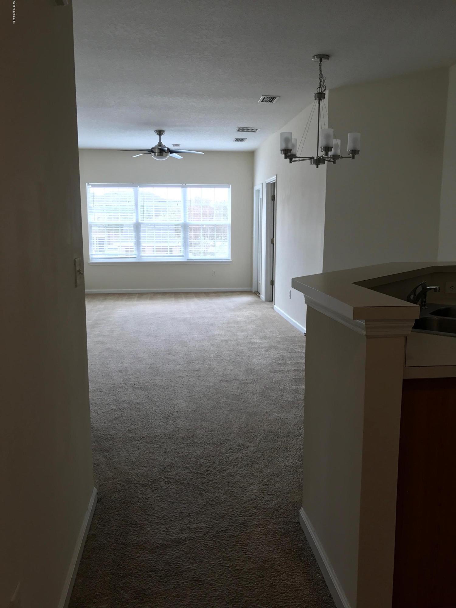 12301 Kernan Forest Boulevard, Unit 2202 Jacksonville, FL 32225 - Photo 17 of 38 en empty room with windows and cabinet