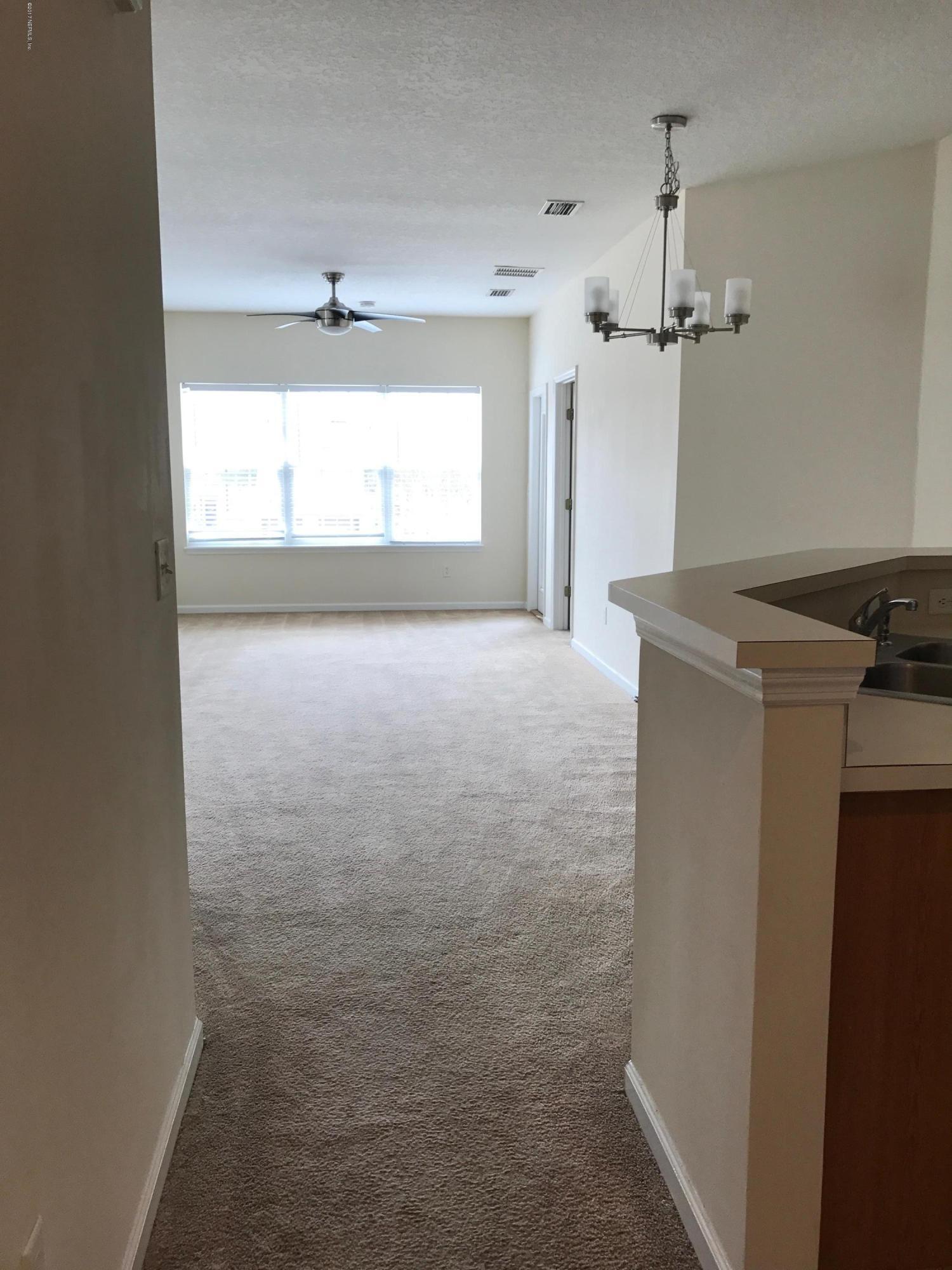 12301 Kernan Forest Boulevard, Unit 2202 Jacksonville, FL 32225 - Photo 19 of 38 en empty room with windows and cabinet