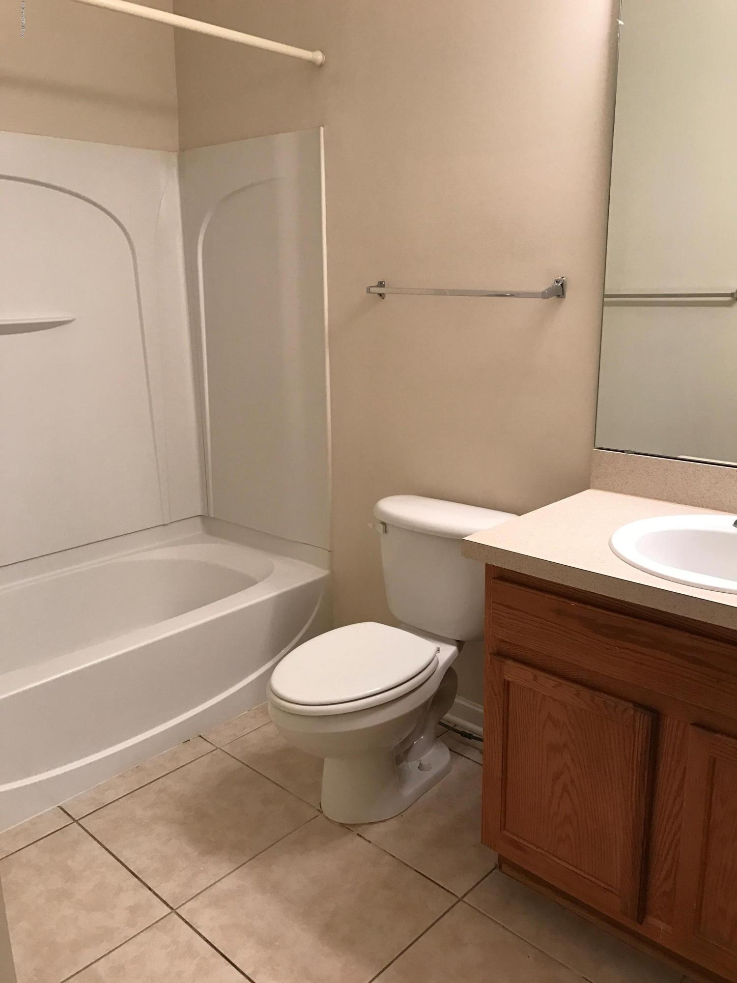 12301 Kernan Forest Boulevard, Unit 2202 Jacksonville, FL 32225 - Photo 22 of 38 a bathroom with a sink a toilet and shower