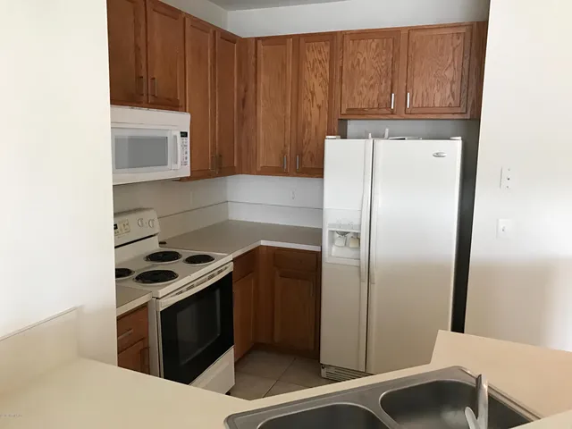a view of a room with a chandelier fan and kitchen view
