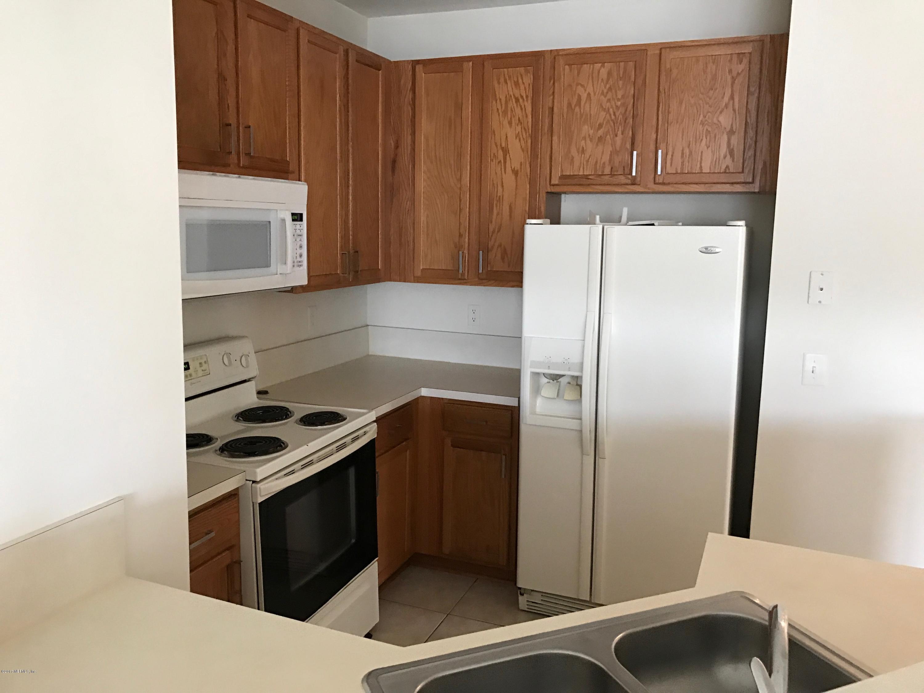 12301 Kernan Forest Boulevard, Unit 2202 Jacksonville, FL 32225 - Photo 28 of 38 a kitchen with a refrigerator and a sink