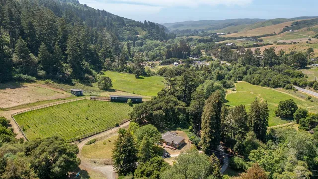 aerial view of a house with a yard and lake view