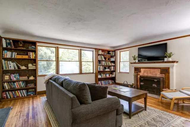 a living room with furniture a flat screen tv and a fireplace