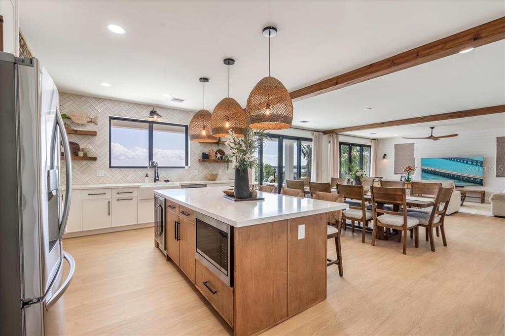 1000 68th Street Marathon, FL 33050 - Photo 26 of 75 a open kitchen with stainless steel appliances granite countertop a stove oven a kitchen island a dining table and chairs with wooden floor