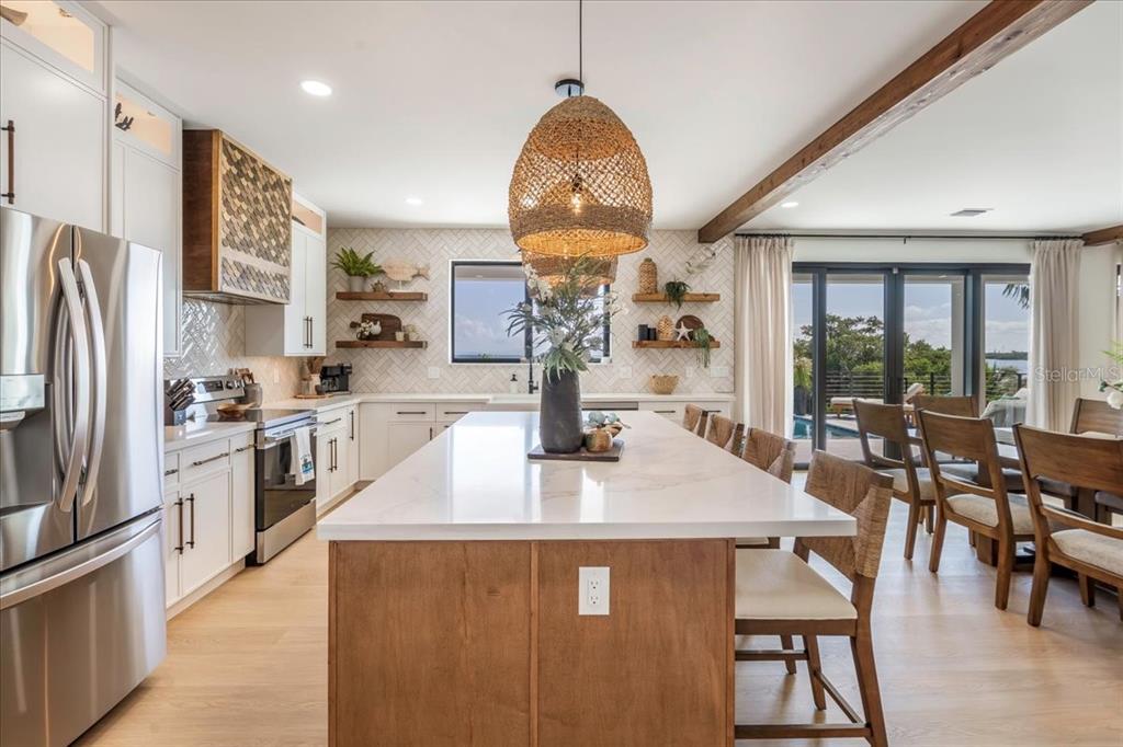 1000 68th Street Marathon, FL 33050 - Photo 29 of 75 a kitchen with stainless steel appliances granite countertop a stove a refrigerator a kitchen island a table and chairs