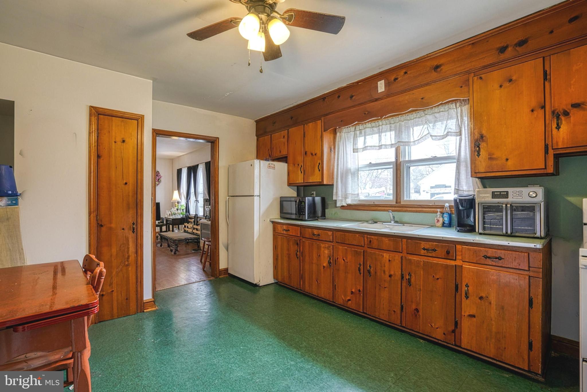 1200 Race Street Cambridge, MD 21613 - Photo 4 of 18 a open kitchen with stainless steel appliances granite countertop a refrigerator a sink dishwasher a stove and a dining table with wooden floor