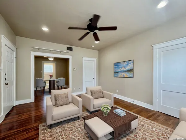 a living room with furniture and a wooden floor
