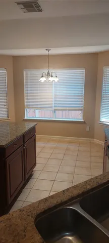 a kitchen with granite countertop a sink and a refrigerator