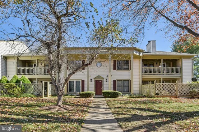 a view of a house with a big yard and large tree