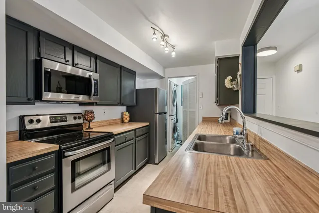 a kitchen with a sink refrigerator and cabinets