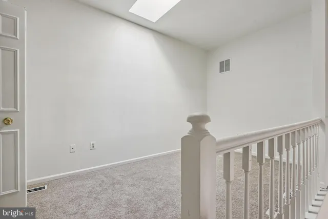 a view of staircase with railing and white walls