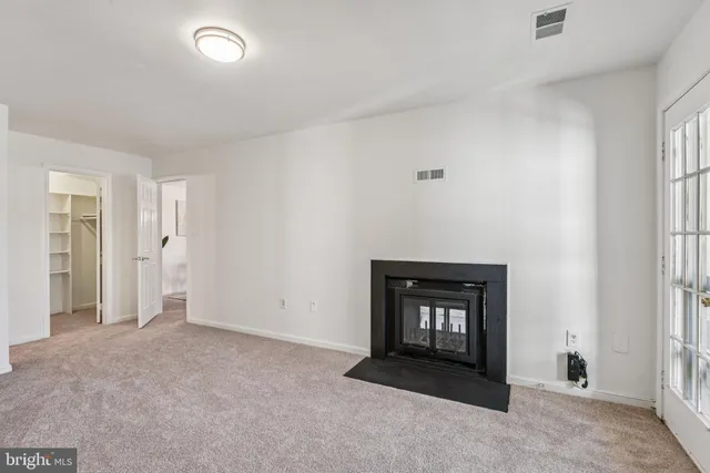 a view of an empty room with window and fire place
