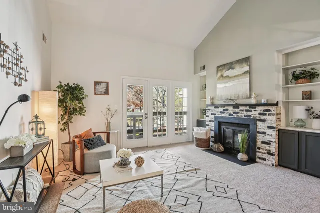 a living room with furniture a fireplace and a potted plant