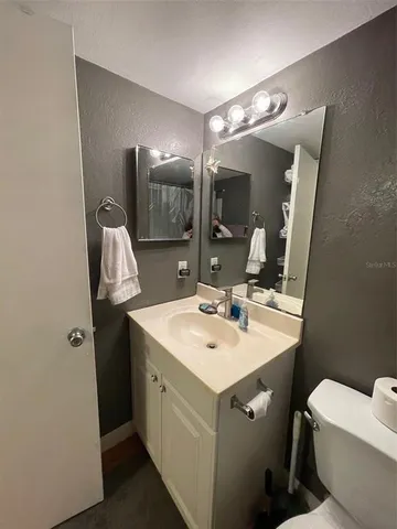 a bathroom with a sink toilet and mirror