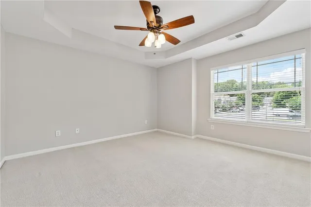an empty room with a window and a fan