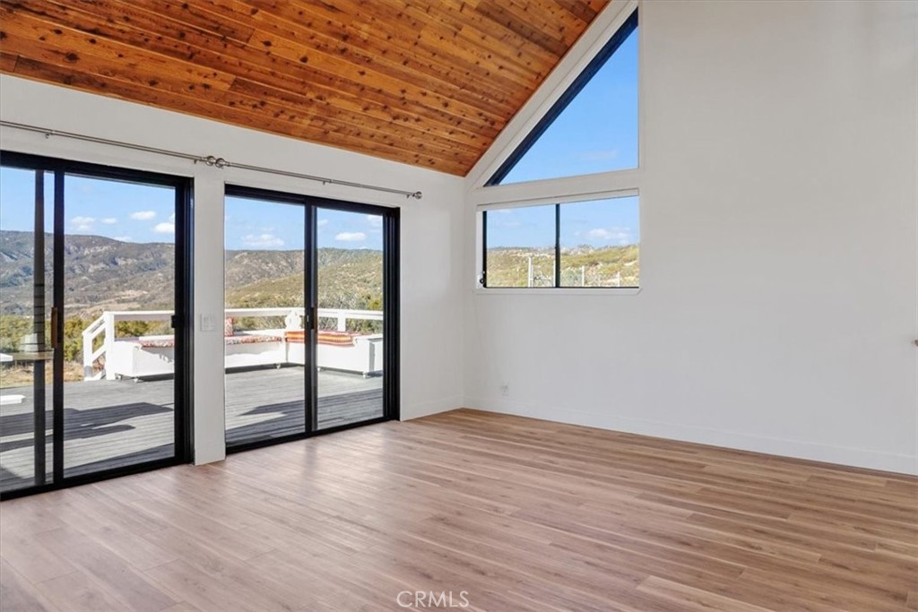 59470 Burnt Valley Road Anza, CA 92539 - Photo 10 of 18 an empty room with wooden floor and windows