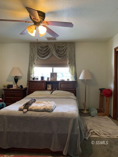 300 South Locust Street Ridgecrest, CA 93555 - Photo 11 of 23 a bed sitting in a bedroom next to a window