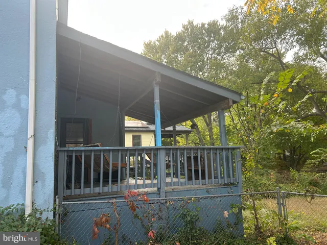 a balcony with wooden floor table and chairs
