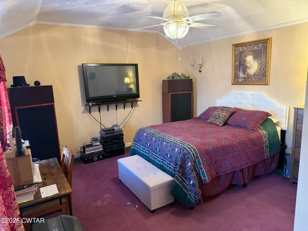 a spacious bedroom with a bed and a flat screen tv