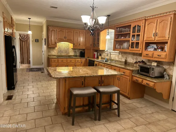 a kitchen with stainless steel appliances granite countertop a sink and a refrigerator