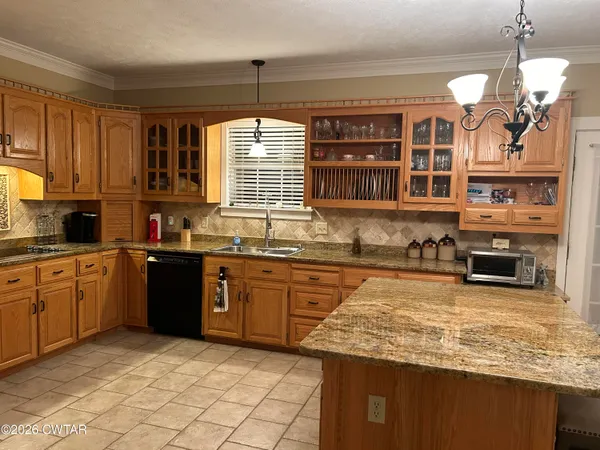 a kitchen with stainless steel appliances granite countertop a stove sink and cabinets