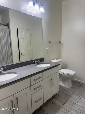 a bathroom with a toilet a sink and mirror